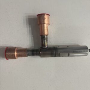 Three-way metal valve body with copper ports and red protective cap