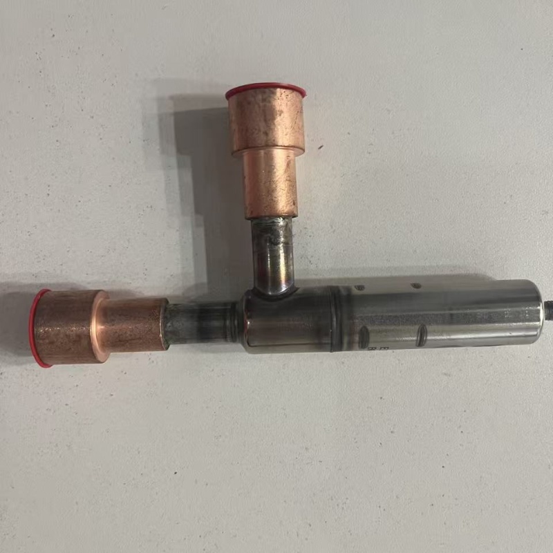 Three-way metal valve body with copper ports and red protective cap