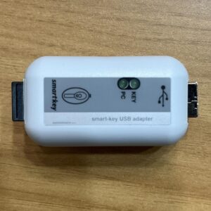 White adapter with marks and dual indicator lights, equipped with ports and protective caps at both ends