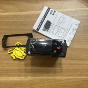 Full view of the thermostat with mounting accessories and manual.