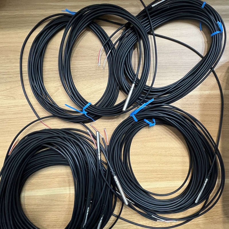 Top-down view of the same batch of temperature sensors, showing the uniform coiled shape and probe structure.