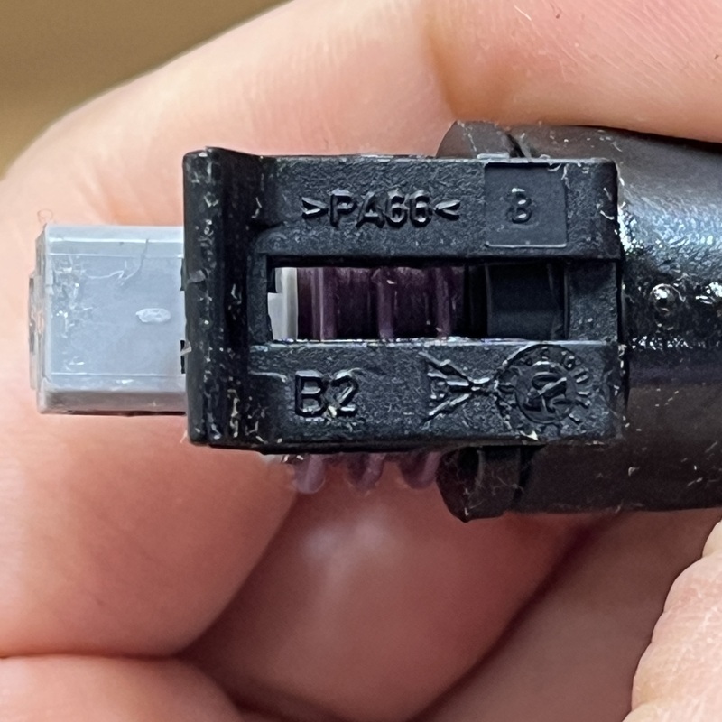 Close-up of the connector clip with material code and recycling mark.