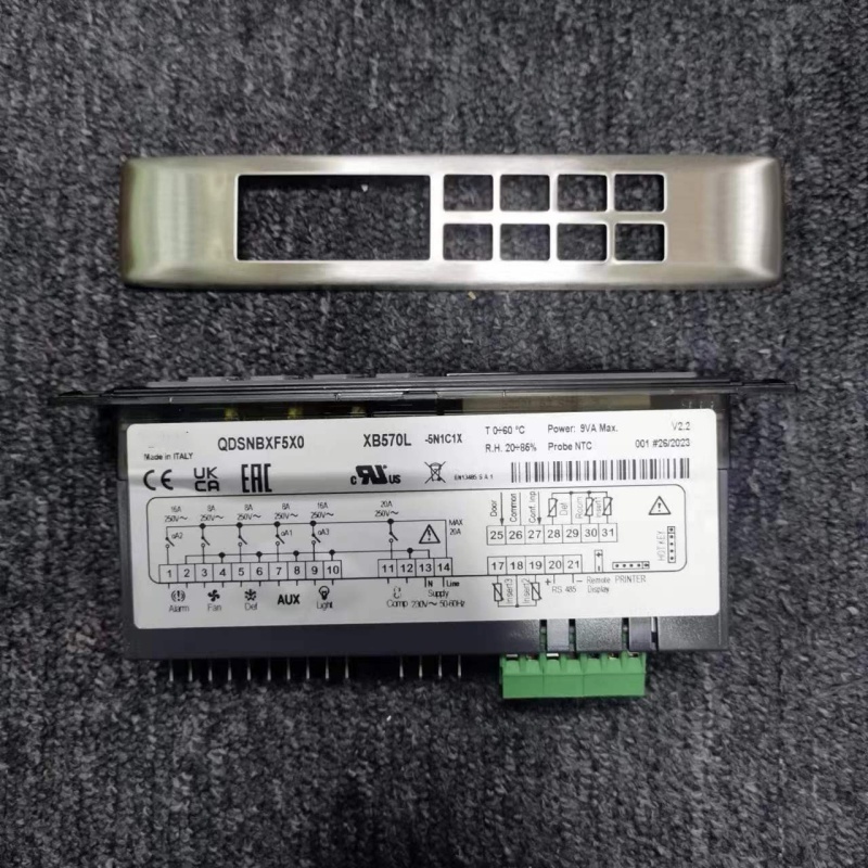 Back of temperature controller, with green terminals, metal pins and metal panel